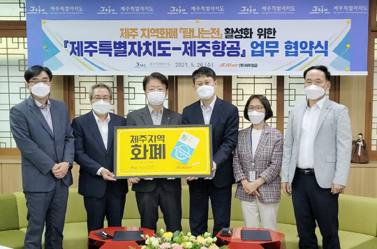 지난 26일 오후 최승현(왼쪽 세번째) 제주특별자치도 행정부지사와 이철행(왼쪽 네번째) 제주항공 대외협력본부장이 제주특별자치도 소통회의실에서 제주항공과 제주특별자치도의 '탐나는전' 활성화 추진 업무협약을 체결후 기념촬영을 하고 있다. <제주항공 제공>